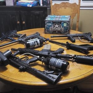 Six paintball guns and box of paintballs.